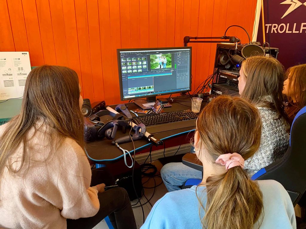 3 jenter som arbeider med foto og video på en datamaskin